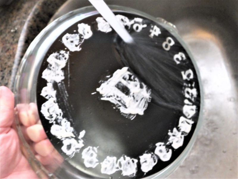 Washing off the etching cream on the Pi pie plate stencil